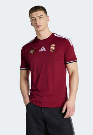 Vinröd sporttröja med vita ränder på axlarna, med broderad Ungerns vapensköld och rund emblem. Tillverkad i lätt tyg.