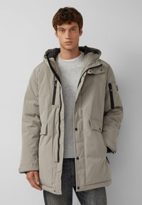 Graue wattierte Parka-Jacke mit Kapuze, Reißverschluss-Brusttasche, zwei vorderen Taschen und kontrastierendem schwarzen Futter. Glatte Textur und lockere Passform.