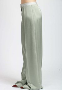 Pantaloni a gamba larga in morbido tessuto verde chiaro. Presentano una vita liscia e cuciture decorative lungo la cucitura laterale.