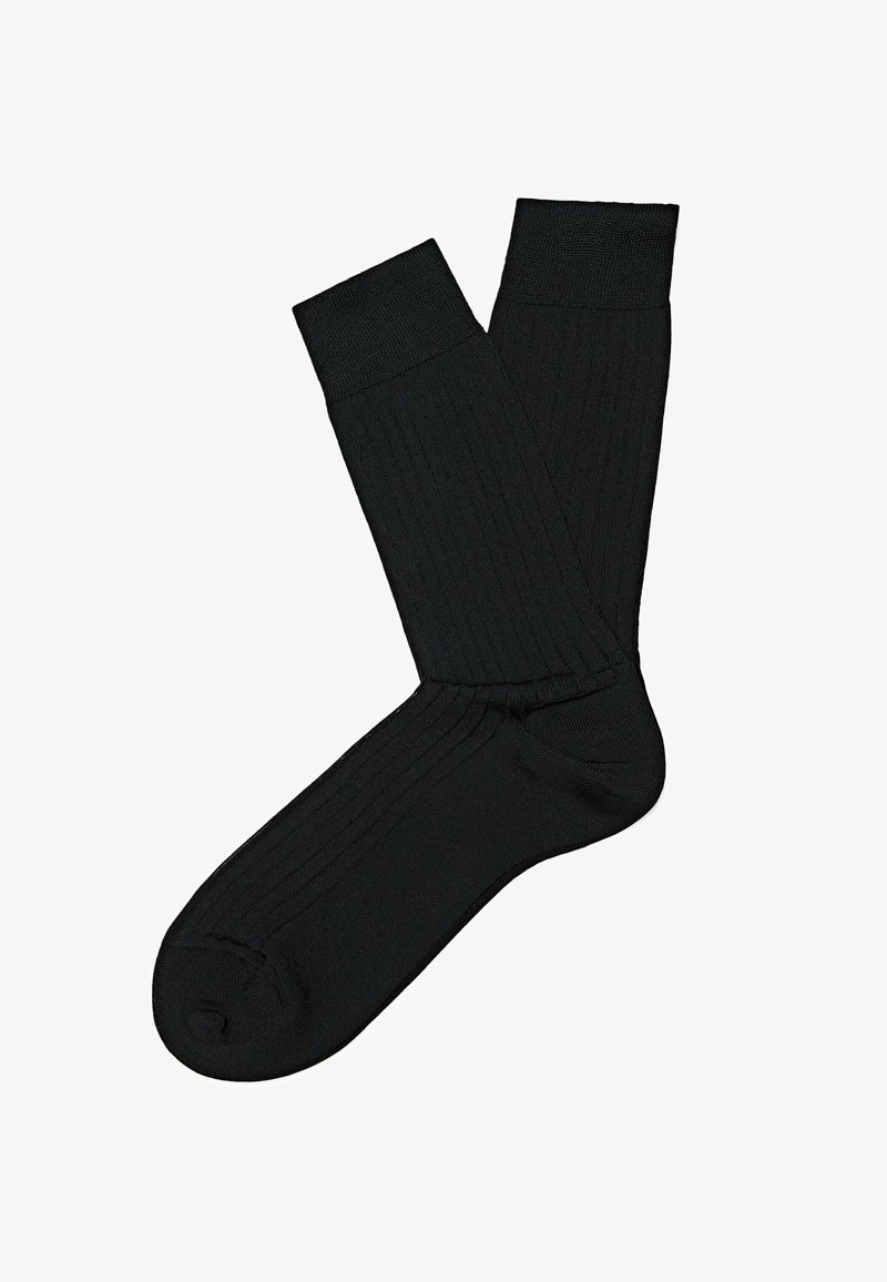Paire de chaussettes noires côtelées montantes, l'une chevauchant l'autre, présentées à plat sur un fond blanc.
