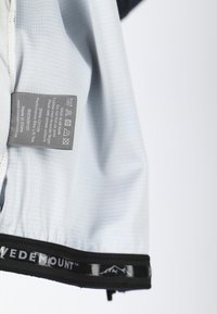 Ljusblå långärmad skjorta i texturerad väv, med en svart logoband vid fållen och en skötsel etikett sydd in på sidan.