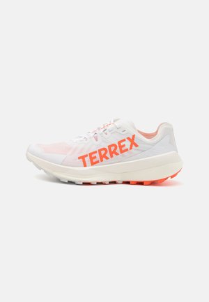 Witte sportief schoen met een bovenwerk van mesh en een fel oranje "TERREX" logo. Beschikt over een gevoerde zool en een gestructureerde grip, ontworpen voor prestaties.