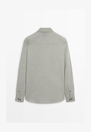 Light gray long-sleeve shirt with a smooth texture, a pointed collar, and buttoned cuffs. Features a back yoke and rounded hem.
