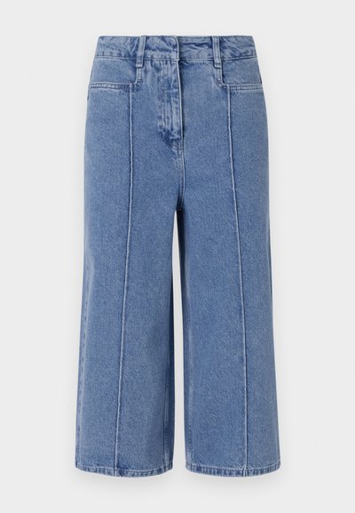 Culottes de denim azul claro com um design de perna larga, apresentando bolsos frontais e traseiros, além de costuras proeminentes ao longo das costuras.