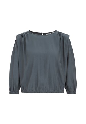 Blusa grigia a maniche lunghe con scollatura rotonda, spalle arricciate e orlo inferiore elasticizzato. Tessuto liscio con un leggero lucido.