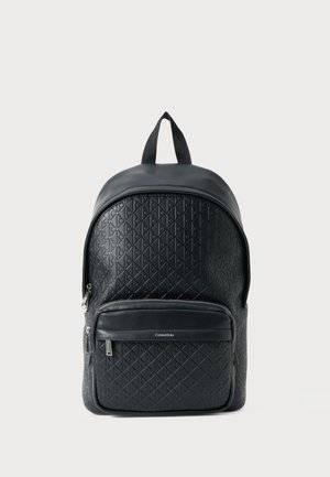 Sac à dos en cuir noir avec un motif en diamant texturé, un dessus arrondi, une poche zippée à l'avant et des bretelles réglables. Comprend une poignée supérieure pour le transport.
