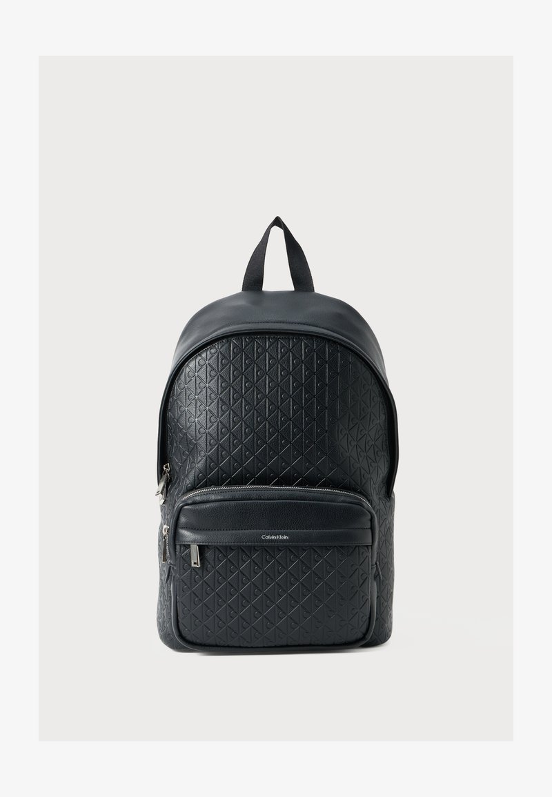 Zaino in pelle nera con motivo a diamante testurizzato, parte superiore arrotondata, tasca con zip frontale e spallacci regolabili. Presenta una maniglia superiore per il trasporto.