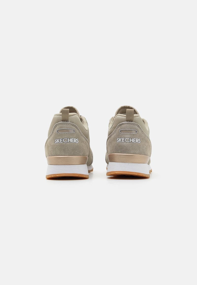 Zapatillas deportivas beige con parte superior de suave gamuza y malla. Cuentan con una entresuela blanca acolchada y suela de goma. Logo "SKECHERS" en el talón.