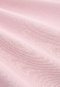 Light pink textured fabric with ribbed pattern, displaying soft folds and subtle sheen. Material appears lightweight and smooth.