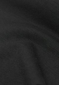 Svart tyg med en slät, strukturerad yta; har ett tätt vävt mönster; verkar mjukt och flexibelt.