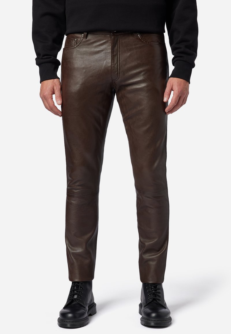 Bruine leren broek met een gladde textuur, slim fit ontwerp, vijf-pocket stijl en gedetailleerde stiksels, in combinatie met zwarte veterschoenen.