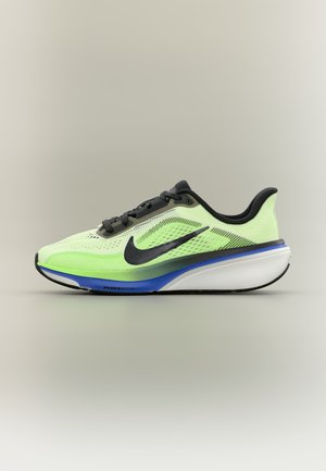 Jasnozielony i czarny but do biegania z niebiesko-białą podeszwą, czarnym logo Nike i czarnymi sznurowadłami, przedstawiony na neutralnym tle.