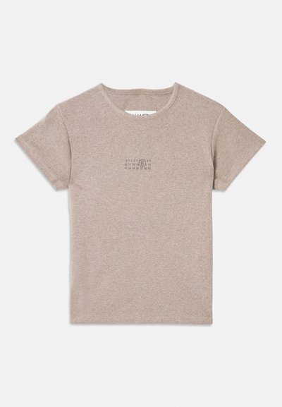 Beige ribbed cotton t-shirt with short sleeves, crew neck, and a small graphic print on the front. Simple design and soft texture.