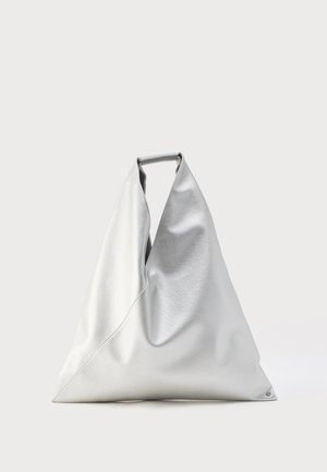 Grande borsa a mano argentata con forma triangolare e texture in pelle morbida, in piedi con manico superiore visibile su uno sfondo semplice.