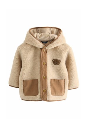 Veste en polaire beige teddy avec un panneau avant en velours côtelé marron, deux poches avant, une capuche et un patch en forme d'ours sur la poitrine.