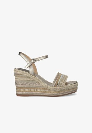 Sandale compensée métallique dorée avec bride de cheville, talon tissé, tissu texturé et bandes accentuées rayées. Semelle de couleur claire avec un motif minimal.