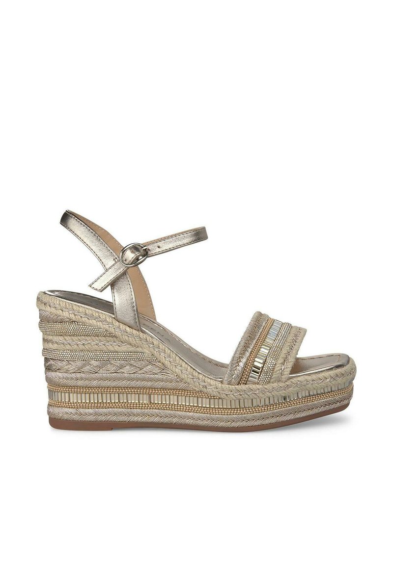 Sandalo a zeppa dorato metallizzato con cinturino alla caviglia, tacco intrecciato, tessuto testurizzato e bande a strisce in accentuazione. Suola chiara con motivo minimale.