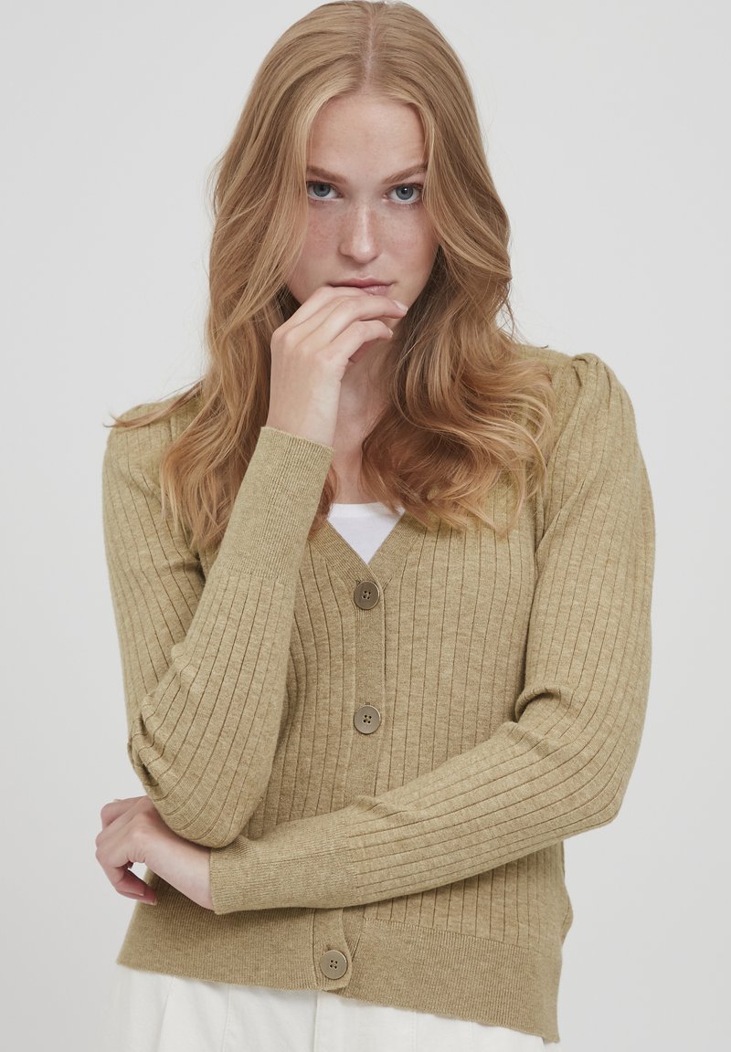 Cardigan beige côtelé avec un col en V, comportant cinq boutons marron, un tissu tricoté texturé et des manches longues ajustées.