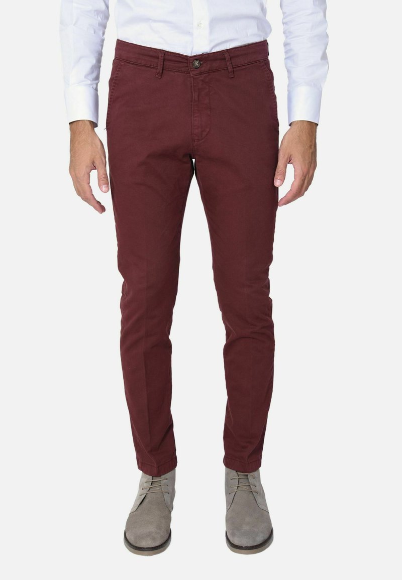 Chinos bordeaux in taglio slim, realizzati in cotone. Caratterizzati da un bottone anteriore con zip, passanti per la cintura e tasche laterali. Abbinati a stivaletti grigi alla caviglia.