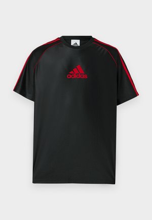 T-shirt de sport noir avec des accents rouges et un logo. Confectionné en tissu lisse et léger. Doté d'un col rond et de manches courtes.