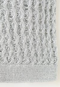 Tissu tricoté gris argenté avec des motifs en relief verticaux ajourés et un ourlet côtelé serré au bas.