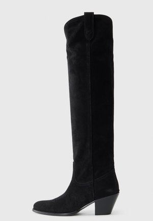 Black suede knee-high boot with a tapered square heel. Smooth texture, rounded toe, and stitching accents along the shaft.