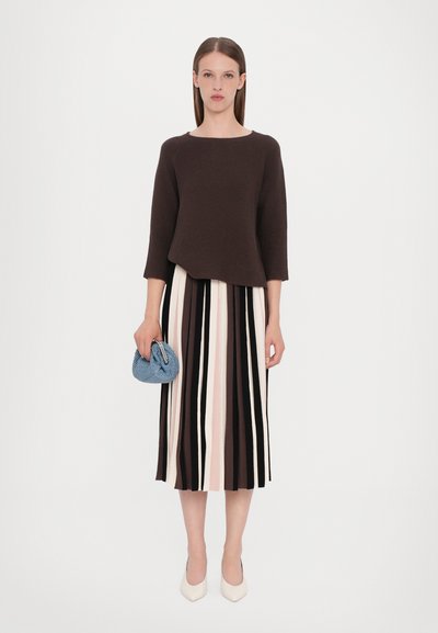 Haut en tricot texturé marron à manches 3/4, associé à une jupe midi plissée à rayures multicolores en crème, rose, noir et marron. Sac bleu clair.