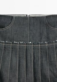 Donkerdenim rok met een geplooid ontwerp. Voorzien van twee voorzakken en zichtbare stiksels in contrasterend licht garen langs de tailleband.