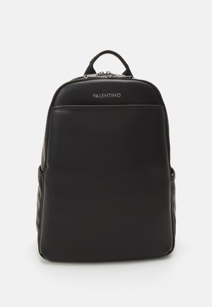 Mustast nahast seljakott, millel on sile tekstuur, ristkülikuline kuju, kaubamärgi logo ülaservas, eesmine lukuga tasku ja kaks küljetaskut.