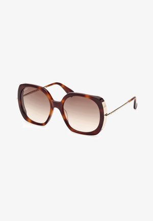 Gafas de sol de gran tamaño en carey con lentes degradados. La montura tiene un acabado brillante y acentos de metal en tono dorado en las patillas.