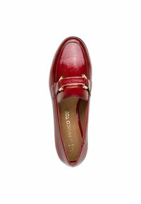 Chaussure en cuir verni rouge avec un bout rond, présentant un détail de boucle en ton doré sur le devant et une doublure intérieure lisse.