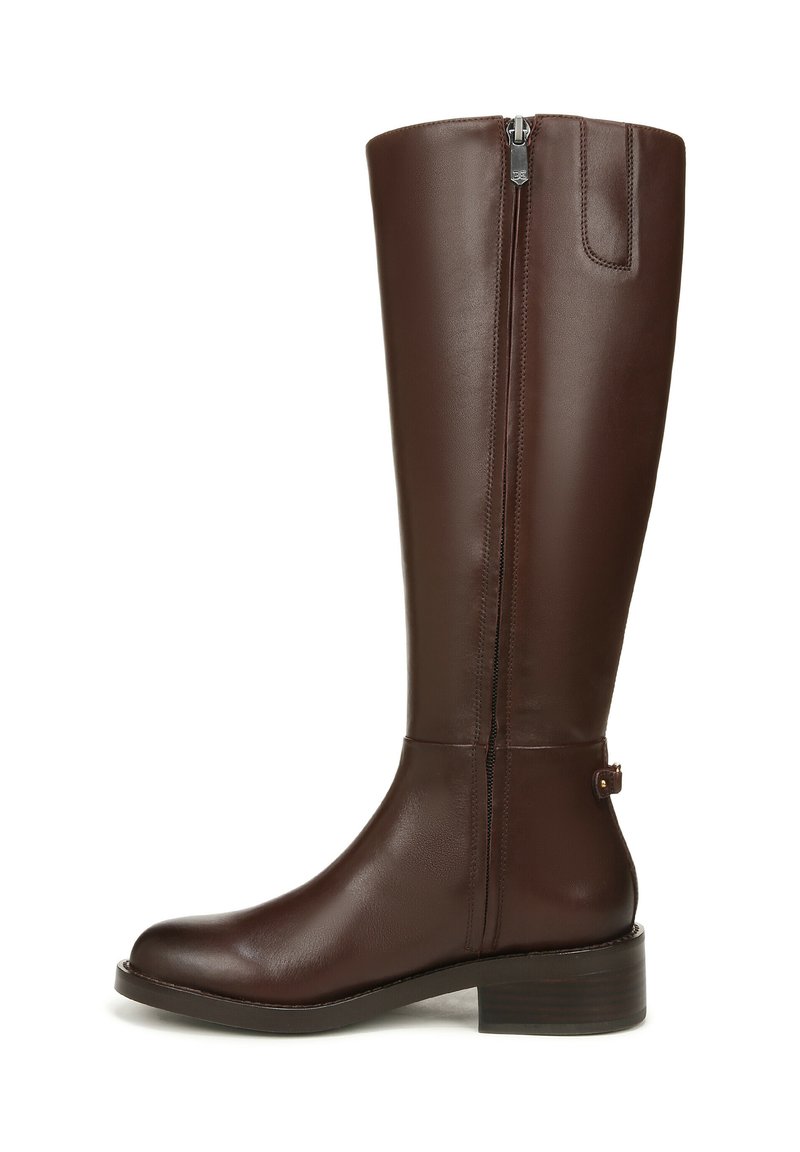 Bruine leren kniehoge laars met een rits aan de zijkant, een ronde neus en een lage gestapelde hak. Heeft een accentband aan de achterkant in de buurt van de hak.