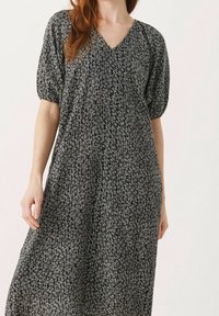 Vestido azul marino con escote en V, mangas cortas abullonadas y un patrón texturizado de líneas blancas. Diseño fluido con un corte relajado.