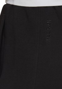 Sudadera negra con un tejido suave y texturizado y un detalle bordado "ALL SZN" en el lateral; diseñada para un ajuste relajado.
