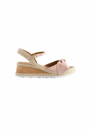 Sandal med kilehæll, en let pink ruskindsoverdel, Sløjfe detajle, justerbar ankelrem og en platform dækket af jute. Hvid gummisål.