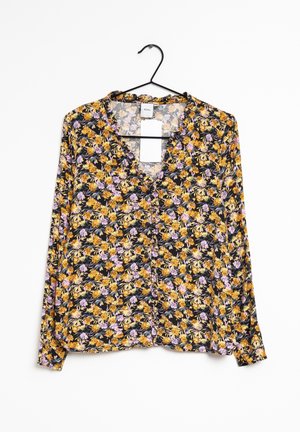 Floral blouse with long sleeves, featuring a black background and a pattern of yellow and purple flowers. Has a V-neck and button detail.