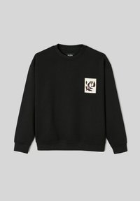 Sweat-shirt noir à manches longues, poignets côtelés et col ras du cou. Présente un patch carré avec un motif floral aux couleurs douces.