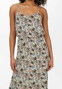 Maxikleid mit floralem Muster, das einen dunklen Hintergrund mit rosa und weißen Blumen zeigt. Verstellbare Spaghettiträger und ein lockerer, geraffter Taillenbereich.