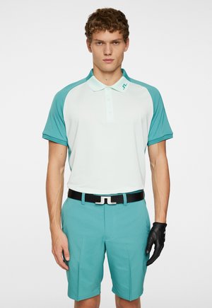 Herre polo skjorte i lyse mintgrøn og teal, kortærmet, struktureret stof, med matchende shorts og et sort bælte med en karakteristisk spænde.