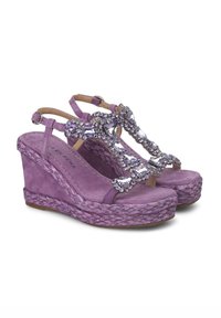Sandali con zeppa viola in finitura scamosciata, con decorazioni in cristallo sulla parte superiore e una suola intermedia in juta intrecciata. Cinturino alla caviglia regolabile.