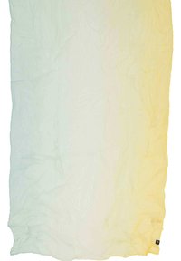 Coperta in tessuto leggero con una sfumatura ombre che va da un blu pallido a un giallo chiaro, caratterizzata da una superficie testurizzata e bordi sfrangiati. Presente un'etichetta con logo nera.