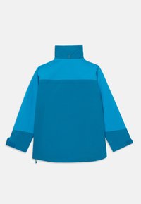 Giacca blu bicolore con maniche lunghe, alto colletto con bottone a pressione e polsini regolabili in Velcro, mostrata da dietro su uno sfondo bianco.