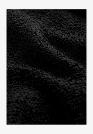 Tessuto nero con superficie strutturata, caratterizzato da fibre morbide e rialzate. Il materiale appare accogliente con sottili variazioni di profondità.