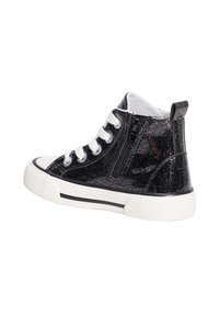 Czarne błyszczące sneakersy typu high-top z białymi sznurówkami i bocznym zamkiem. Gruba biała gumowa podeszwa z teksturowanymi detalami i czarnymi akcentami.
