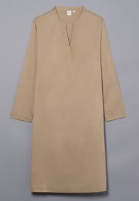 Beige pitkähihainen mekko, jossa on V-pääntie ja kaksi etutaskua. Kangas näyttää sileältä ja siinä on lievä kiilto, ja leikkaus on suora.
