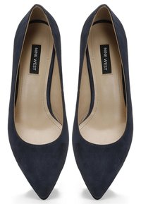 Navy semišové lodičky s špičatou špičkou mají hladkou světlou vnitřní část, minimalistický design a elegantní siluetu, která předvádí klasický styl.