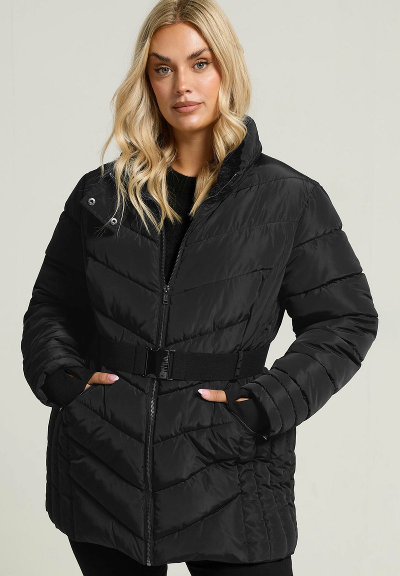 Gestepptes schwarzes Puffer-Jackett mit hohem Kragen, Reißverschluss auf der Vorderseite, tailliertem Gürtel und seitlichen Taschen. Verfügt über ein Chevron-Steppmuster.