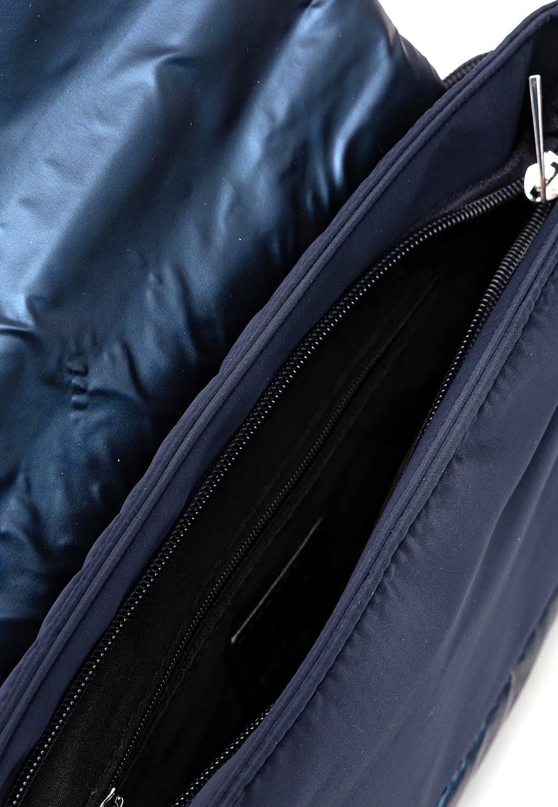 Borsa blu navy con un materiale esterno elegante, caratterizzata da un interno liscio e lucido. Contiene scomparti con zip per una conservazione organizzata.