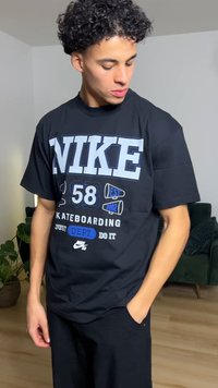 Juoda Nike marškinėliai su baltais ir mėlynais grafikos tekstais bei piešiniais, tarp kurių yra "58", "Skateboarding" ir Nike logotipas apačioje.