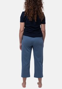 Marinblus med kort ärm i kombination med ljusblå, korta byxor, tillverkade av mjukt tyg med en slät yta, designade för komfort och rörelsefrihet.